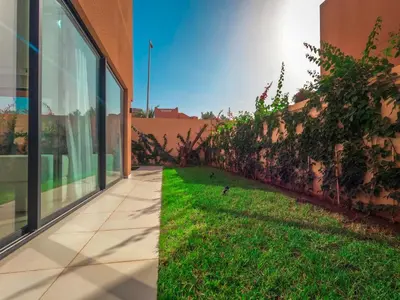 a walkway next to a building with a green yard at Dar Zohra in Marrakech