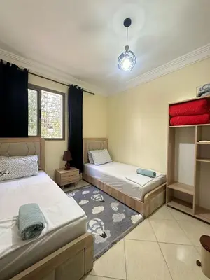 a bedroom with two beds and a rug at Charming and Comfortable Room Near Marrakech Airport in Marrakech