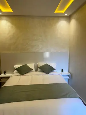 a bedroom with a large bed with two green pillows at Apparently 2 bedrooms- baby equipment in Marrakech