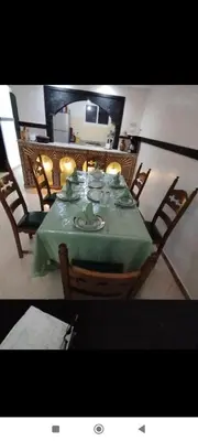 a dining room table with a green table cloth and chairs at Riad Benhamou 3 in Marrakech