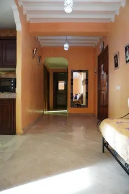 a living room with orange walls and a large mirror at Maison Nadia in Marrakech
