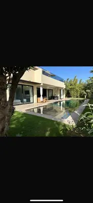 a large house with a swimming pool in front of it at Villa Five rafinity house in Marrakech