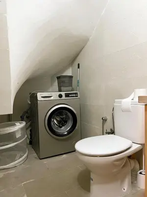 a bathroom with a washing machine and a toilet at Bohemian Chic Duplex Marrakech in Marrakech