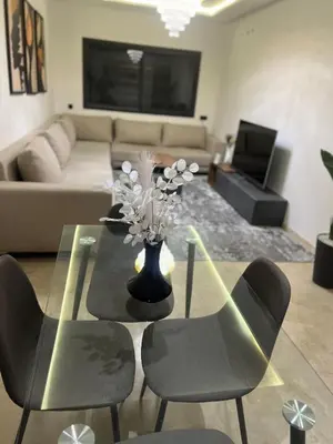 a living room with a table and chairs and a couch at Cozy Apartment With Pool 5 min from Guéliz in Marrakech