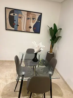 a glass table and chairs in a room with a painting at Cozy Apartment With Pool 5 min from Guéliz in Marrakech