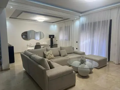 a living room with a couch and a table at Duplex spacieux avec jaccuzi in Marrakech