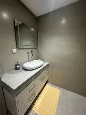 a bathroom with a sink and a tv on the wall at Duplex spacieux avec jaccuzi in Marrakech