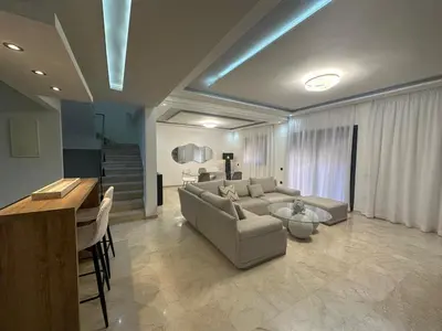 a living room with a couch and a table at Duplex spacieux avec jaccuzi in Marrakech
