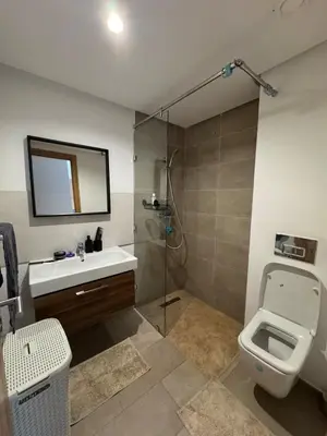 a bathroom with a toilet and a sink and a shower at Rez de Jardin T3 Piscine Noria in Marrakech