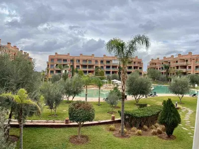 a park with palm trees and a large building at Peaceful heaven in Marrakech