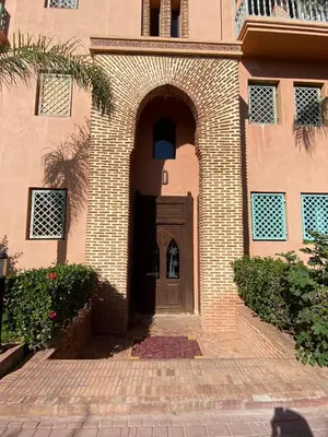 a brick building with a brown door and an archway at Peaceful heaven in Marrakech