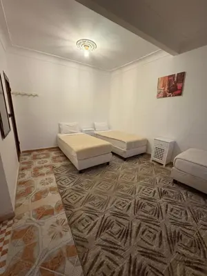 two beds in a room with a carpet at Daryussef 114 in Marrakech