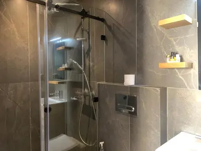 a bathroom with a shower with a glass door at Appartement Mazal in Marrakech