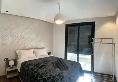 a bedroom with a bed and a large window at Appartement Mazal in Marrakech