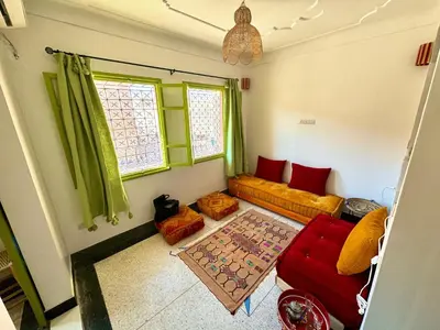 a living room with green curtains and a couch at Maison au cœur de Marrakech in Marrakech