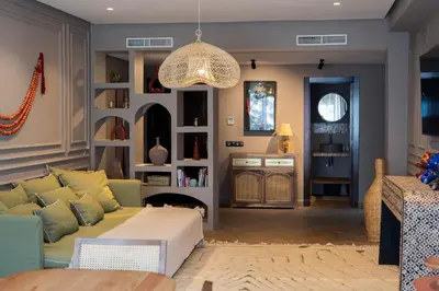 a living room with a couch and a chandelier at Beldi garden - appartement avec jardin et gouvernante in Marrakech
