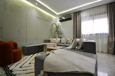 a living room with a bed and a couch at Appartement Cosy et Moderne Accès 4 piscines in Marrakech