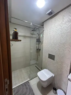 a bathroom with a toilet and a glass shower at Apartment proche gueliz in Marrakech