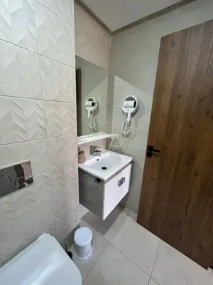 a bathroom with a sink and a toilet and a door at Apartment proche gueliz in Marrakech