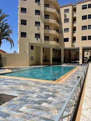 a swimming pool in front of a building at Apartment proche gueliz in Marrakech