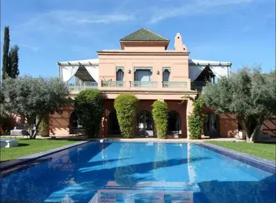 a large house with a swimming pool in front of it at Luxury villa - AC- 5BR-11P- Palmeraie Marrakech in Marrakech