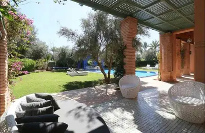 a patio with a table and chairs and a pool at Luxury villa - AC- 5BR-11P- Palmeraie Marrakech in Marrakech