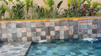a swimming pool with a tiled wall and plants at villa Argan, Confort & Modern avec PiscineChauffée in Marrakech