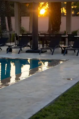 a group of chairs next to a swimming pool at Villa Yliane in Marrakech