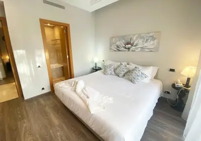 a bedroom with a white bed with pillows on it at Luxueuse Appart Vizir 106 in Marrakech