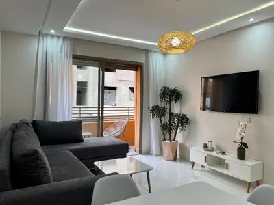 a living room with a couch and a tv at Modern Stay 3 bedroom City Center with Balcony in Marrakech