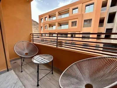 a balcony with two chairs and a building at Modern Stay 3 bedroom City Center with Balcony in Marrakech