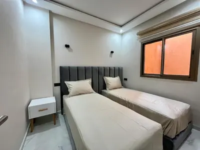 two beds in a small room with a window at Modern Stay 3 bedroom City Center with Balcony in Marrakech