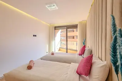 two beds in a room with a window at Large elegant 2BR Apt in Gueliz in Marrakech