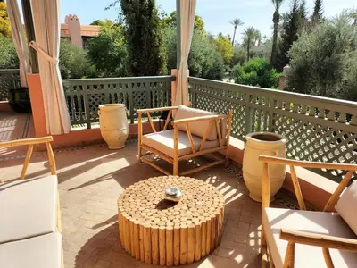 a patio with a table and chairs on a balcony at Marrakech Palmeraie 2 appartement 3 ch 7 pers résidence avec piscine in Marrakech