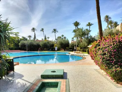 a swimming pool in a resort with palm trees at Marrakech Palmeraie 2 appartement 3 ch 7 pers résidence avec piscine in Marrakech