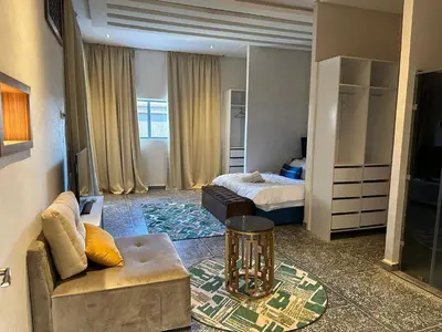 a hotel room with a bed and a couch and a table at Villa akiba in Marrakech