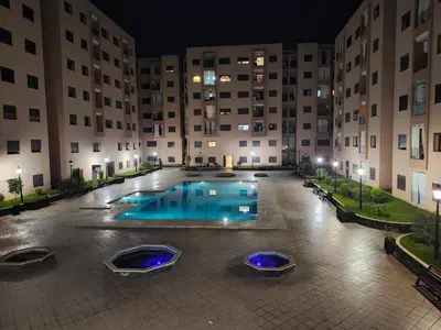 an empty pool in a courtyard of a building at night at Bel appartement au cœur de Marrakech in Marrakech