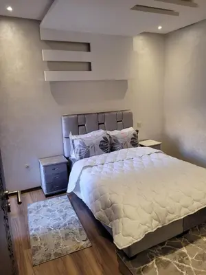 a bedroom with a large bed with a white comforter at Bel appartement au cœur de Marrakech in Marrakech