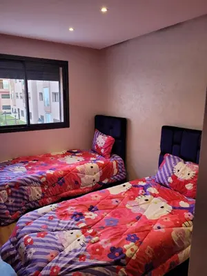 two beds sitting next to each other in a room at Bel appartement au cœur de Marrakech in Marrakech