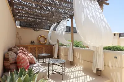 a patio with two chairs and a pergola at mon riad in Marrakech