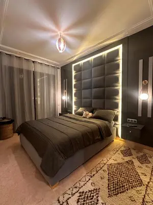 a bedroom with a large bed with a large headboard at Marrakech Oasis, Residence Ennaim 1 in Marrakech