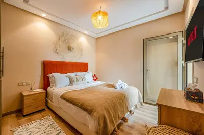 a bedroom with a bed and a dresser and a mirror at Apartment center marrakech - Gueliz in Marrakech