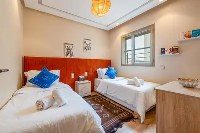 a bedroom with two beds with blue pillows at Apartment center marrakech - Gueliz in Marrakech