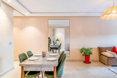 a dining room and living room with a table and chairs at Apartment center marrakech - Gueliz in Marrakech