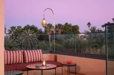 a patio with a couch and two tables on a balcony at Villa Amelya - Amelkis Golf in Marrakech