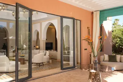 a living room with glass doors and a table at Villa Amelya - Amelkis Golf in Marrakech
