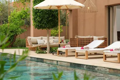 a pool with lounge chairs and an umbrella next to a pool at Villa Ty Habibi - Super 5 Bedroom with Private Heated Pool by the Golf Amelkis in Marrakech