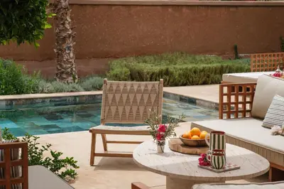 a patio with a table and chairs and a pool at Villa Ty Habibi - Super 5 Bedroom with Private Heated Pool by the Golf Amelkis in Marrakech