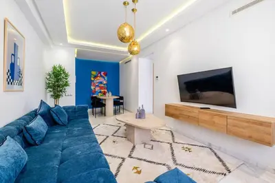 a living room with a blue couch and a tv at Cozy & Elegant appart in hypercenter of Marrakech in Marrakech