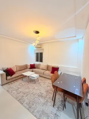 a living room with a couch and a table at Appartement Tachfine lumineux FAMILY in Marrakech